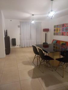 een woonkamer met een eettafel en stoelen bij Apart272 in Río Cuarto