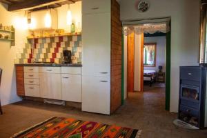 a kitchen with white cabinets and a stove at Casa Batrana in Zece Hotare
