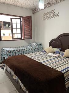 dwa łóżka siedzące w pokoju z dwoma oknami w obiekcie Suíte com cozinha para casal w mieście Araruama