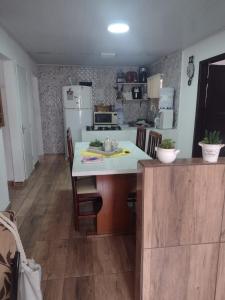 y cocina con mesa, sillas y nevera. en Casa Praia Ubatuba Sâo Francisco do Sul 3 quartos en São Francisco do Sul