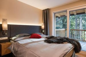 a bedroom with a bed with a large window at Piz Aich Natur Chalet Panorama in Avelengo