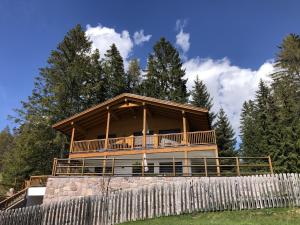 a house on a hill with a wooden fence at Piz Aich Natur Chalet Panorama in Avelengo