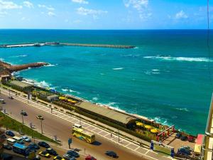 a view of the ocean and a beach with cars at Salvatore Rooms -Corneish Street in Alexandria