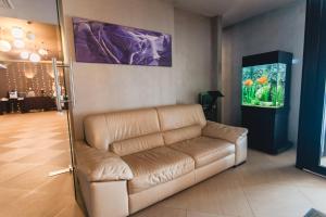 a leather couch in a room with a fish tank at Caro Boutique Hotel in Oradea