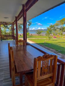 a wooden table and chairs on a porch with a view at Rimlay Bay View in Ko Yao Noi