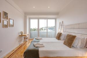 Belém River Apartment View في لشبونة: غرفة نوم بسرير كبير مع نافذة كبيرة