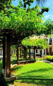 a garden with a wooden pergola in the grass at Neroki's Crib Cozy & Luxurious Staycation! in Cebu City