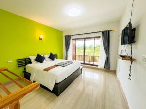 a green bedroom with a bed and a television at Rimlay Bay View in Ko Yao Noi