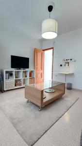 ein Wohnzimmer mit einem Couchtisch und einem TV in der Unterkunft CENTER Santa Cruz, Alojamiento céntrico con gran terraza, cocina , salón y baños, todo privado in Santa Cruz de Tenerife