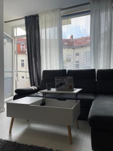 a living room with a couch and a coffee table at Bright: Flat with Balcony - Kitchen - Free Parking in Berlin