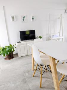 een witte eetkamer met een witte tafel en stoelen bij Hermoso espacio en Temperley in Temperley
