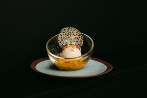 a glass bowl with a dessert in it on a plate at Hotel Restaurant Krone in Sulzbach am Kocher