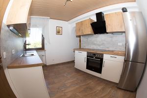 a kitchen with white cabinets and a stainless steel refrigerator at Gästehaus Lorz in Höchstadt an der Aisch