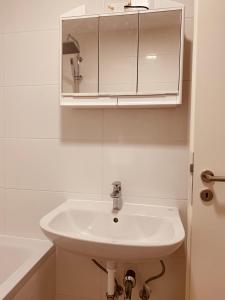 baño con lavabo blanco y armario en Nice private room in Luxembourg City, en Luxemburgo