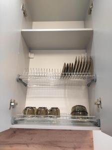 eine Küche mit einem Regal mit Töpfen und Pfannen in der Unterkunft ЖК "Nomad" 2-комнатный ЛЮКС в центре города in Almaty