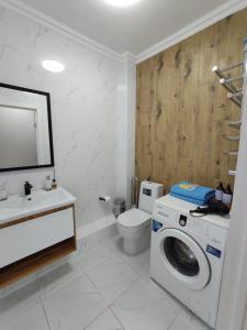 ein Badezimmer mit Waschmaschine und Toilette in der Unterkunft ЖК "Nomad" 2-комнатный ЛЮКС в центре города in Almaty