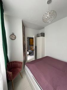 - une chambre avec un lit violet et une chaise dans l'établissement Bright: Flat with Balcony - Kitchen - Free Parking, à Berlin