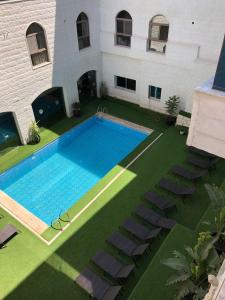 a swimming pool on a lawn next to a building at The RN Hotels in Wadi Musa