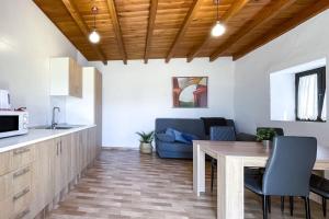 a kitchen and living room with a table and a couch at Tindaya Sol Smartworking by Babiniliving in Tindaya