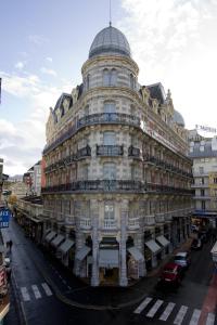 un grand bâtiment blanc avec un dôme en haut. dans l'établissement Grand Hôtel Moderne, à Lourdes