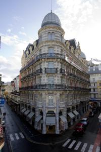 un grand bâtiment blanc avec un dôme en haut. dans l'établissement Grand Hôtel Moderne, à Lourdes