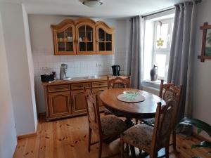 a kitchen with a wooden table and a table and chairs at Pension Am Buhnenkopf in Tangermünde