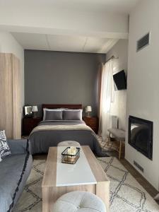 a bedroom with a bed and a couch and a table at Lagos Apartment in Elati