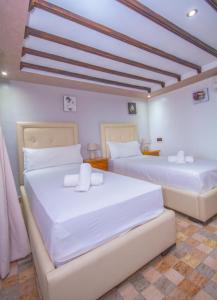 2 camas en una habitación con paredes blancas en Casa NORTE, en Chefchaouen
