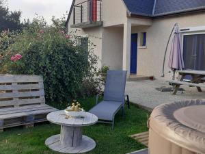 una silla azul y una mesa en un patio en La Trémouchère, en Gesvres