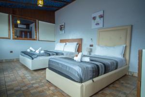 2 camas en una habitación con paredes azules en Casa NORTE, en Chefchaouen