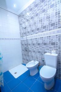 La salle de bains est pourvue d'une douche et de toilettes blanches. dans l'établissement Casa NORTE, à Chefchaouen