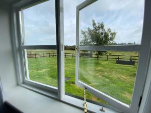 an open window with a view of a field at Seahorse Cottage in Helston +1 photo