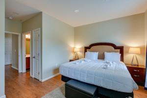 a bedroom with a large bed with white sheets at Capitol Heights Apartment about 8 Mi to National Mall! in Capitol Heights