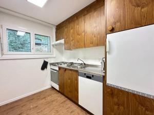 uma cozinha com um frigorífico branco e armários de madeira em Alpine magic for the whole family near Zermatt em Täsch