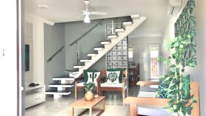 a living room with a staircase with chairs and plants at Casa Luna in Porto Seguro