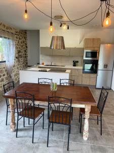 uma cozinha e sala de jantar com uma mesa de madeira e cadeiras em Mas Bô Regard em Aiguèze