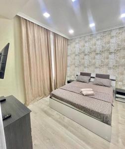 ein Schlafzimmer mit einem großen Bett und einem TV in der Unterkunft Comfortable apartament 1st in Chişinău