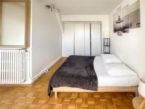Un dormitorio con una cama con una manta negra. en LE COCON VERSAILLAIS en Versailles