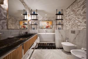 a bathroom with a sink and a tub and a toilet at GA Palace Hotel & Spa, a XIXth-Century Villa in Porto