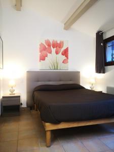 a bedroom with a bed with a painting on the wall at Le Clos des Galéjades in Porquerolles