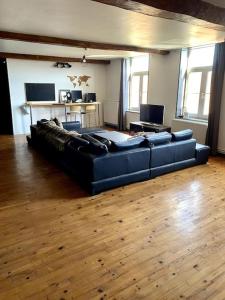 a living room with a blue couch and wooden floors at La Ferme in Ascq