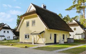 een geel huis met een zwart dak bij Reetdachhaus 13 Auf Usedom in Kutzow