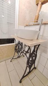 um lavatório branco numa mesa na casa de banho em Osteria l'iero d'Eima' em Meleze