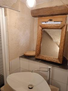 a bathroom with a white sink and a mirror at Osteria l'iero d'Eima' in Meleze