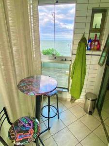 a table and a stool in a kitchen with a window at Ocean Flat 407 in Vila Velha