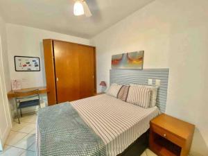 a bedroom with a bed and a wooden cabinet at Ocean Flat 407 in Vila Velha