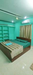 a large bed in a room with blue walls at RUSHITHA HOME STAY-AC Rooms-FREE WIFI-FLAT TV- KITCHEN-DOOR SERVICE-NEAR TO ALIPIRI in Tirupati