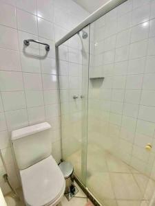 a bathroom with a toilet and a glass shower at Ocean Flat 407 in Vila Velha +15 photos