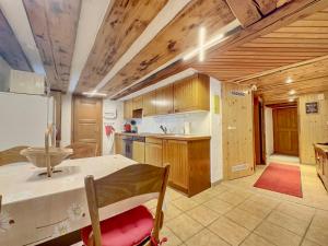 a kitchen with wooden cabinets and a table and a refrigerator at Les Antilles l Bucolique l 6pers in Vercorin