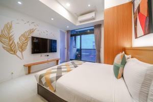 a bedroom with a bed and a tv on a wall at Hua Su Travel B&B in Dongshan